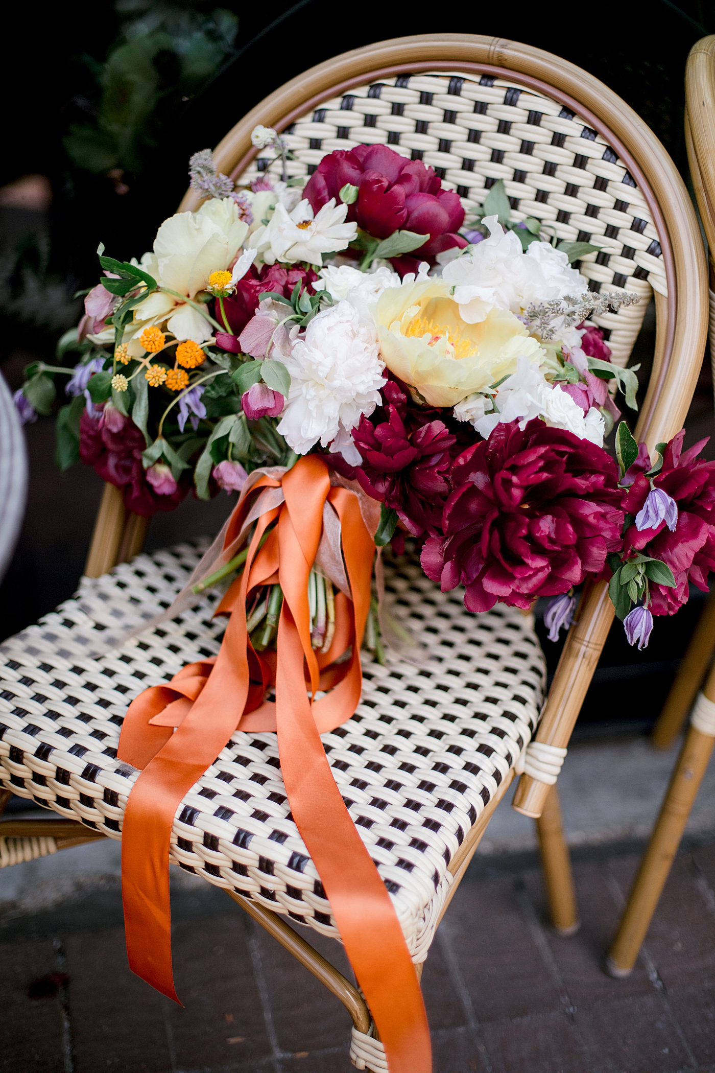 Colorful bridal bouquet sitting on a bistro chair | Photo by Hope Helmuth Photography