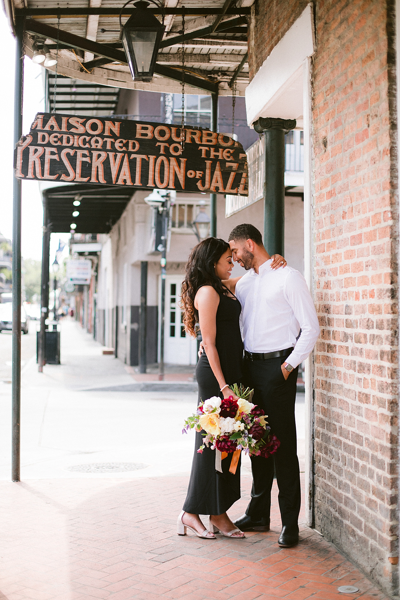 Couple snuggling on the sidewalk walking the french quarter | Photo by Hope Helmuth Photography