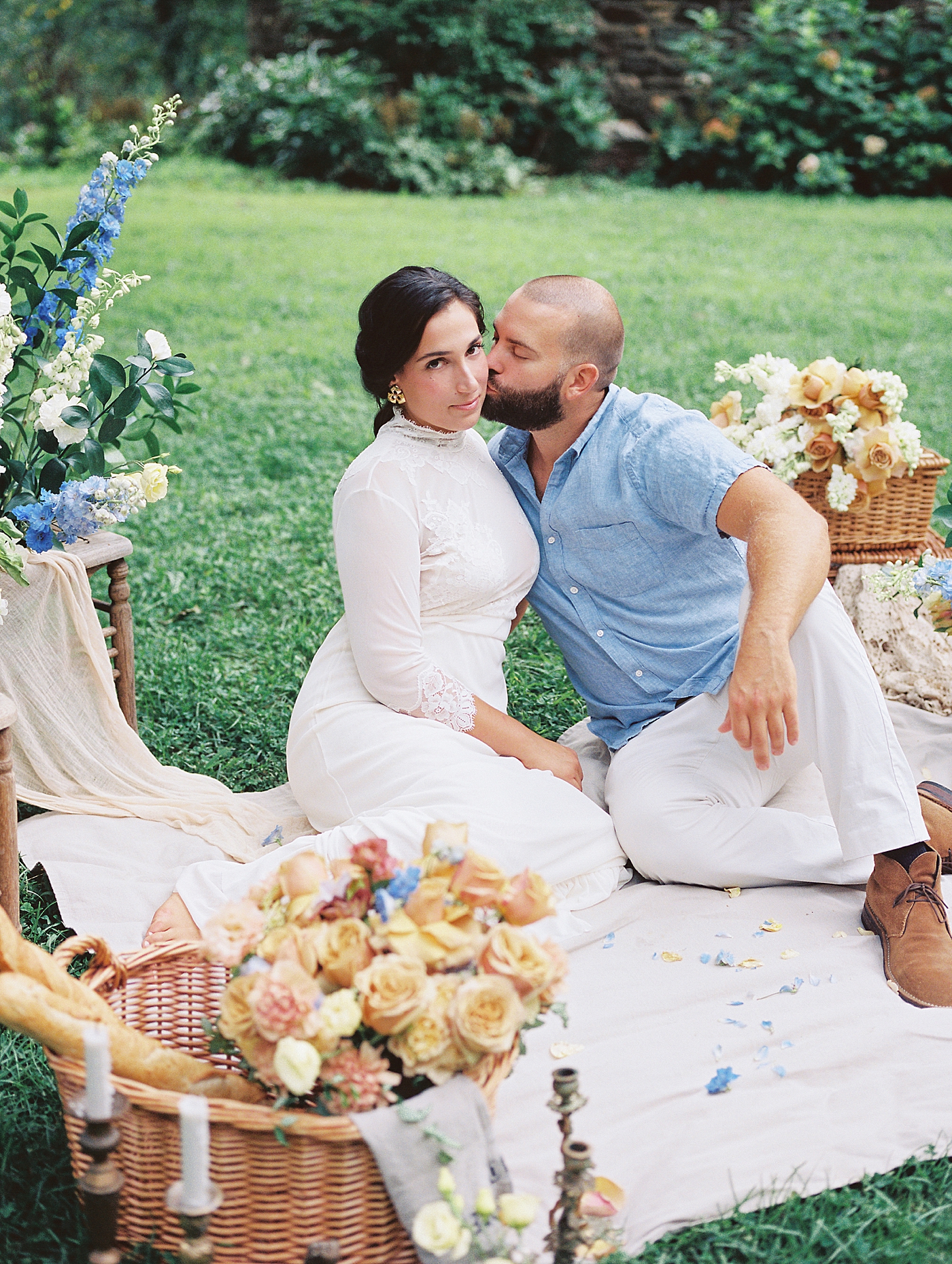 Groom kissing bride on the cheek at a picnic | Styling and Planning Engagement Sessions with Hope Helmuth Photography