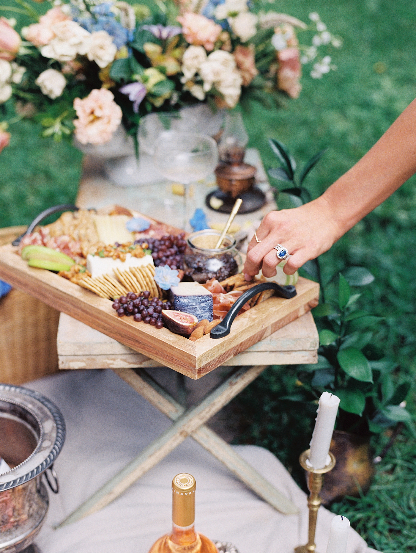 A hand taking a piece of cheese from a charcuterie board | Styling and Planning Engagement Sessions with Hope Helmuth Photography