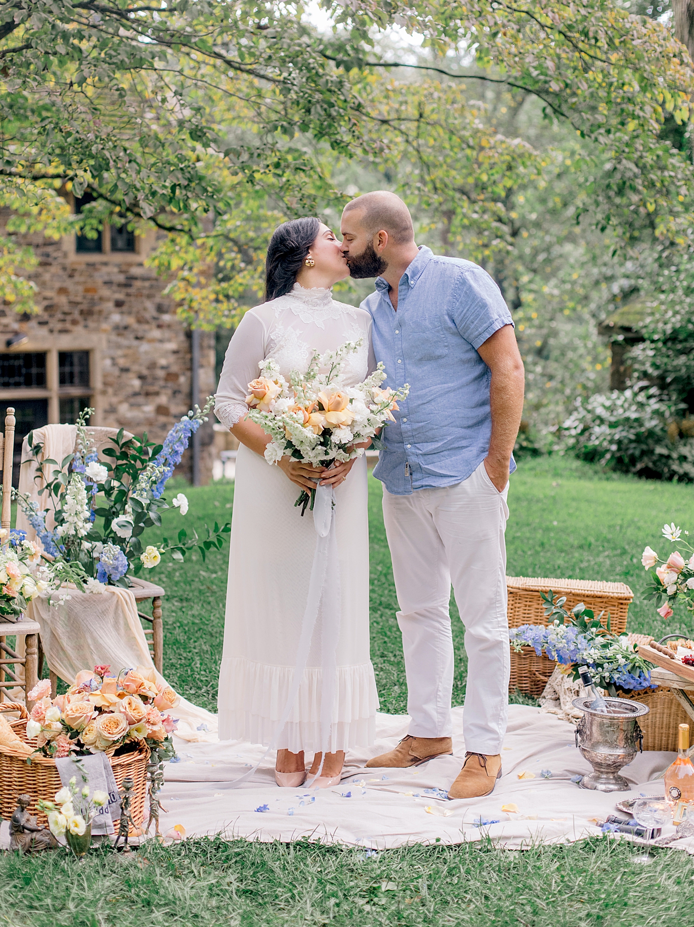 Bride and groom kissing at their picnic full of flowers | Styling and Planning Engagement Sessions with Hope Helmuth Photography