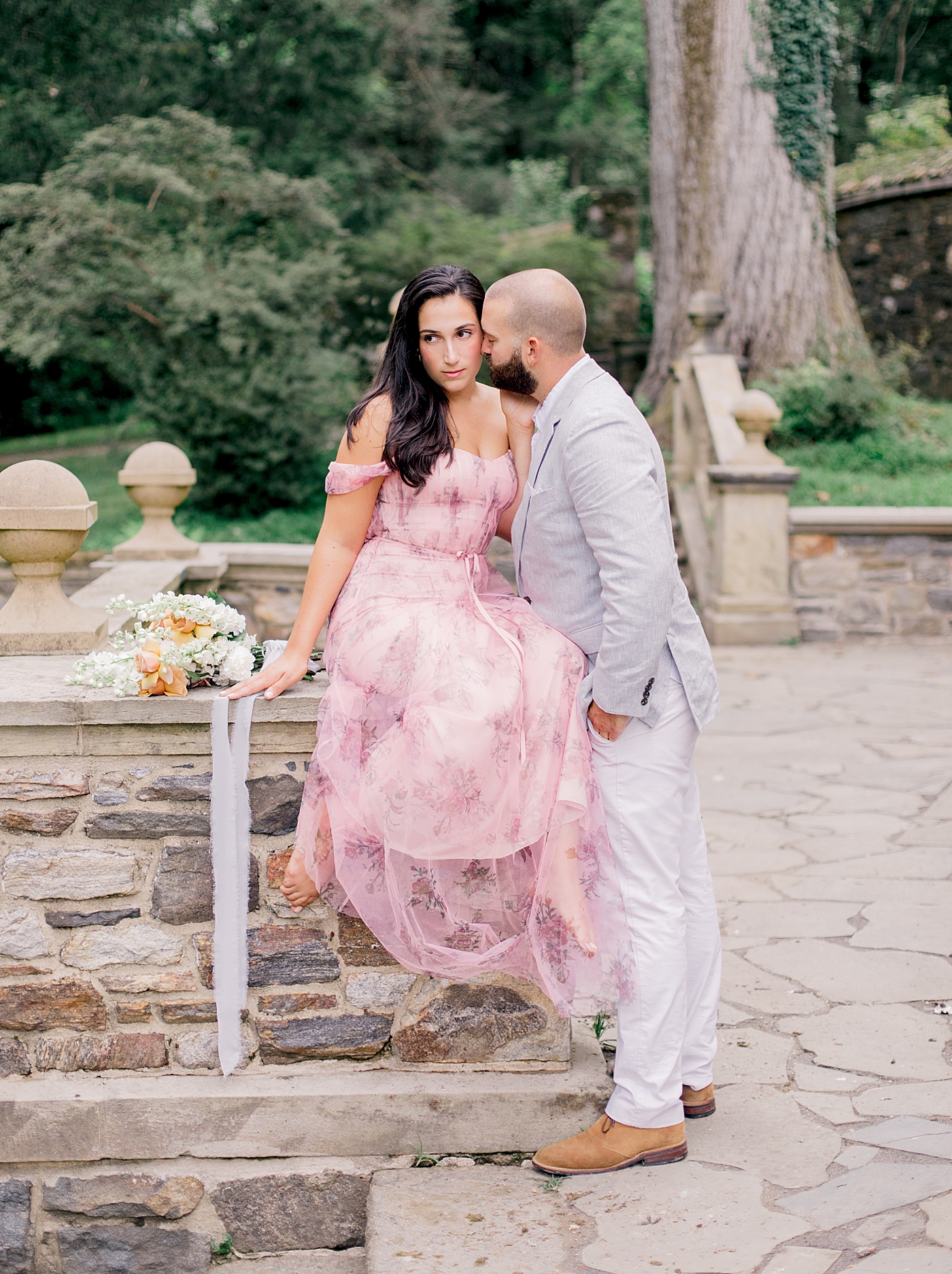 Couple snuggling sitting near a stone wall | Styling and Planning Engagement Sessions with Hope Helmuth Photography