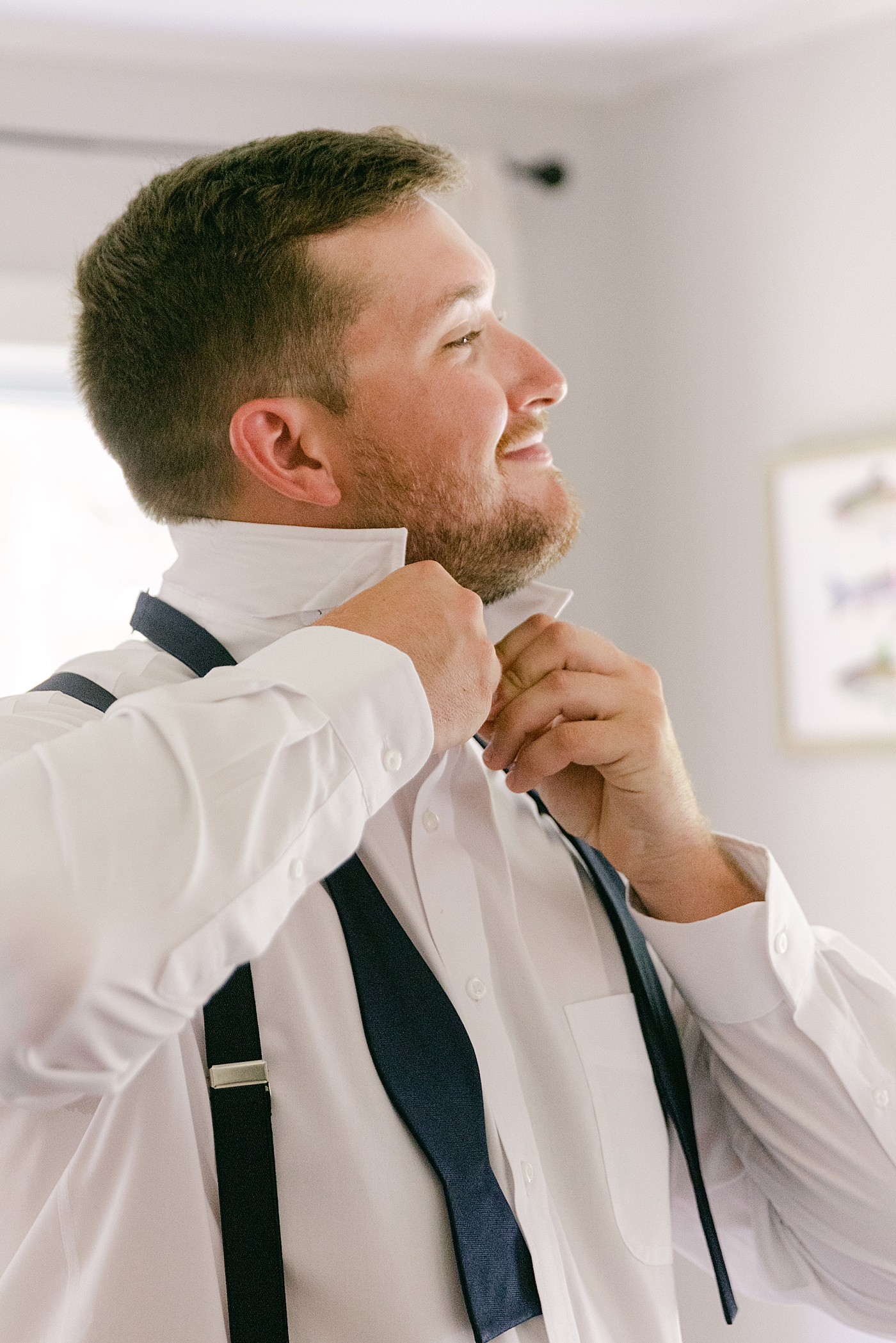Groom putting on his bowtie | Image by Hudson Valley Wedding Photographer Hope Helmuth