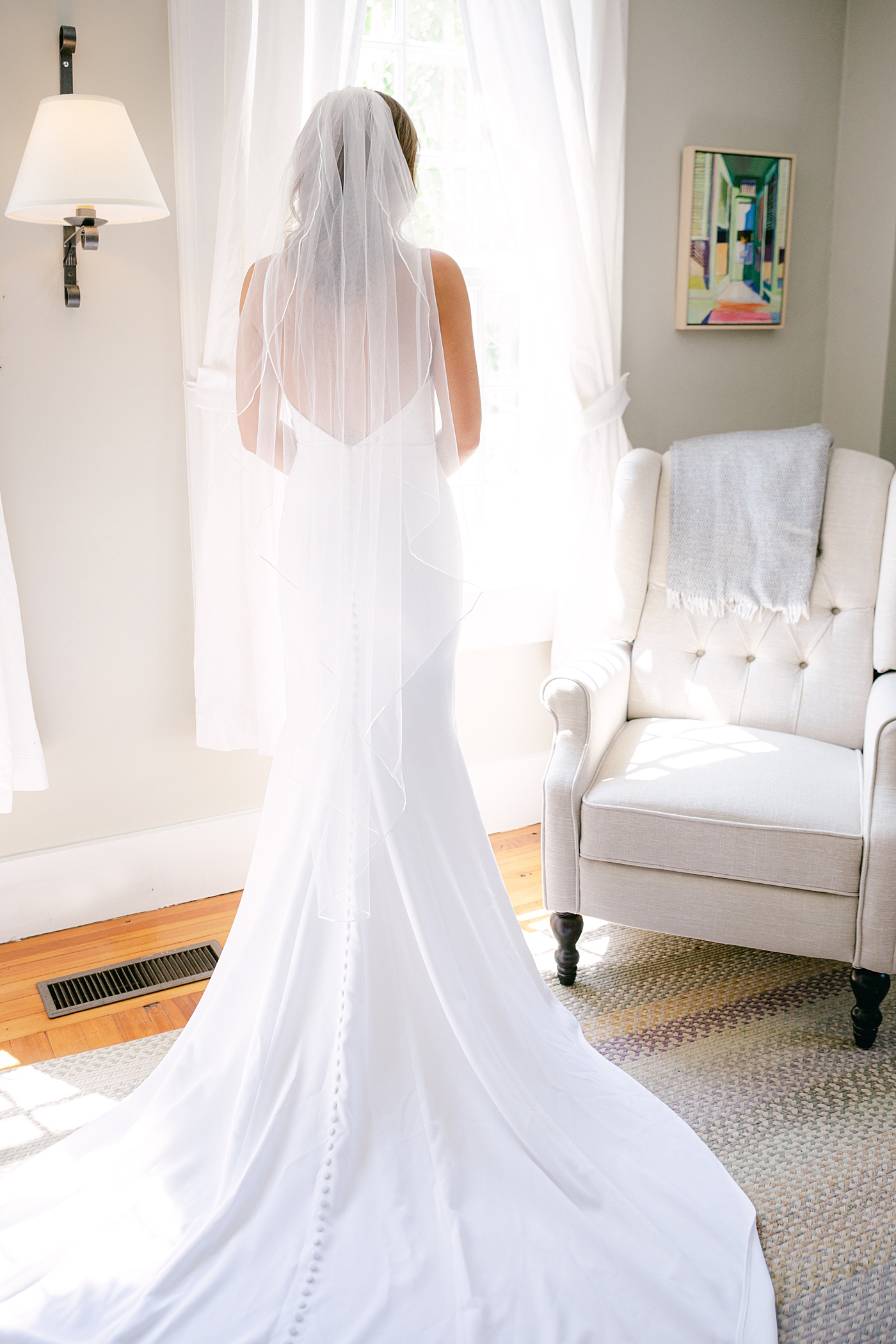 Bride standing near a window | Image by Hope Helmuth Photography