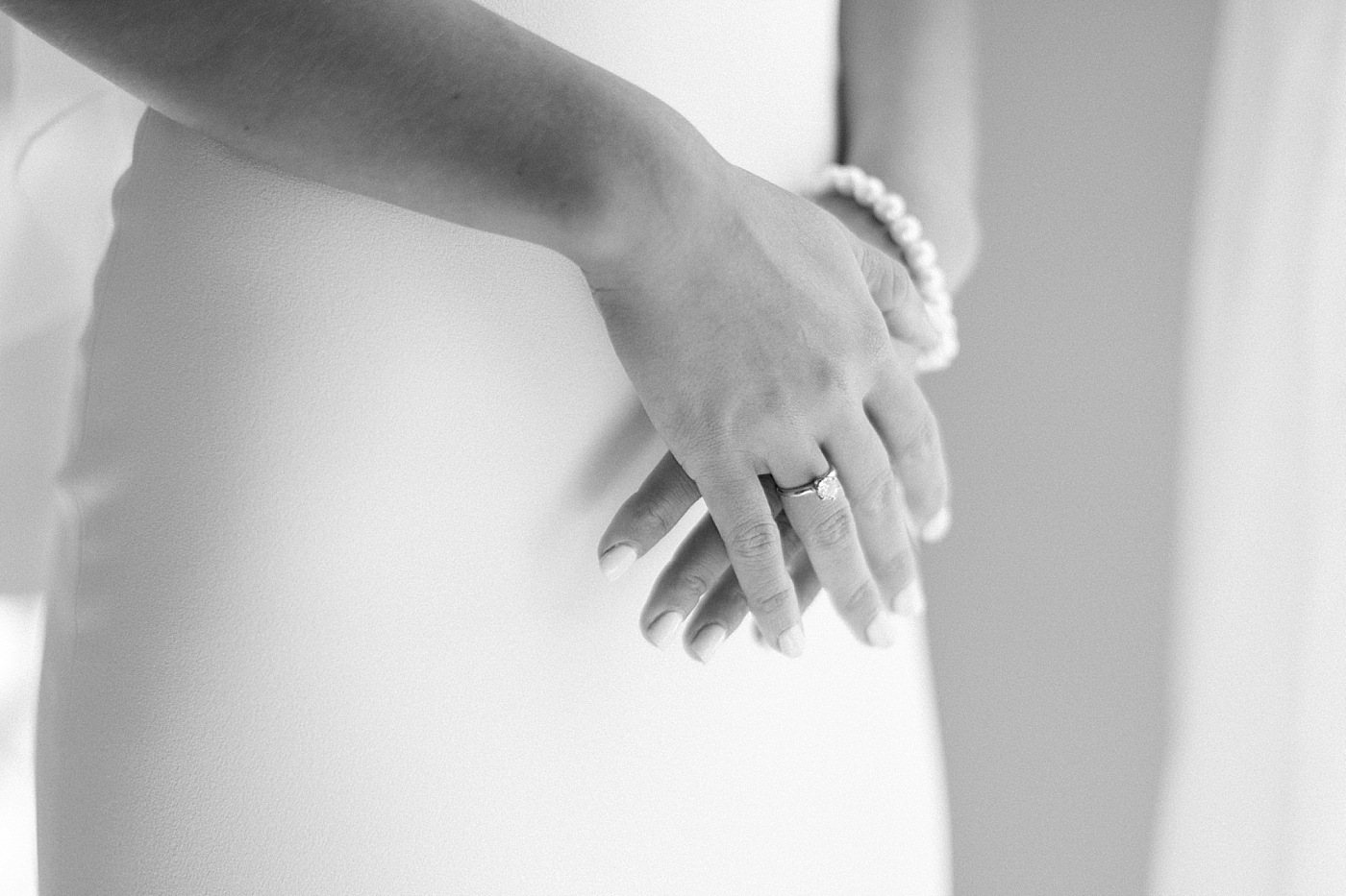 Black and white detail image of bride with her hands crossed | Image by Hope Helmuth Photography