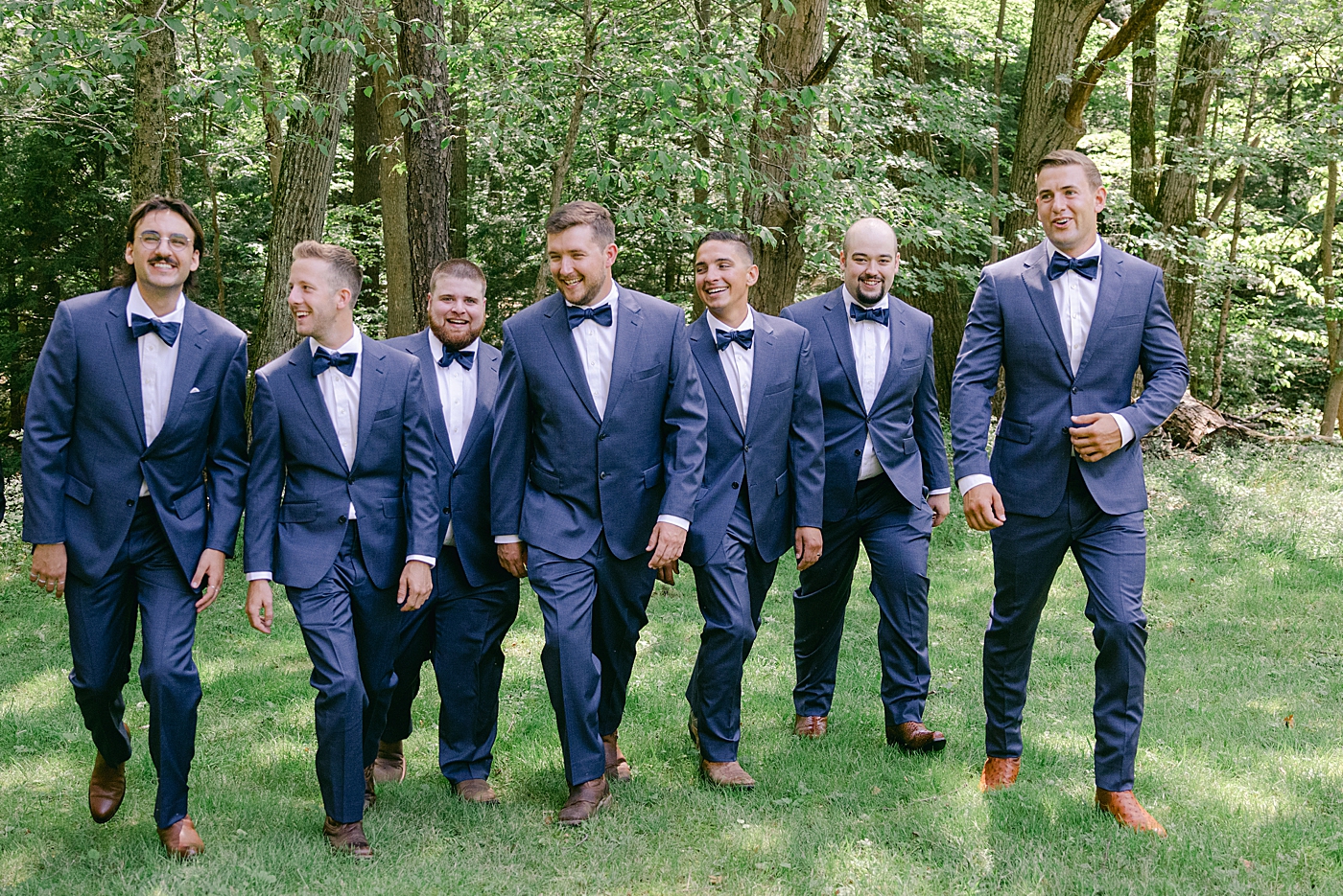 Groom with groomsmen laughing while walking | Image by Hudson Valley Wedding Photographer Hope Helmuth