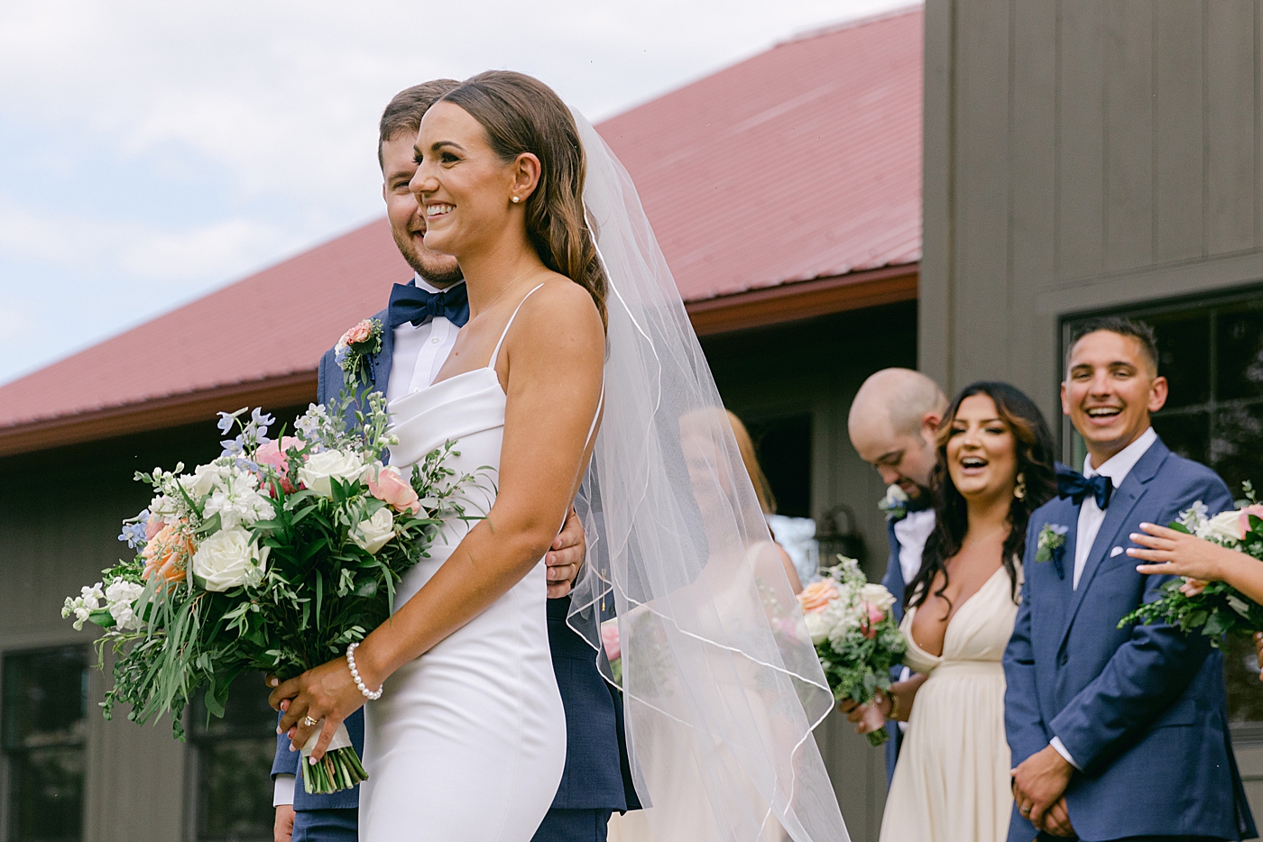 Bride and groom laughing during wedding party photos | Image by Hope Helmuth Photography