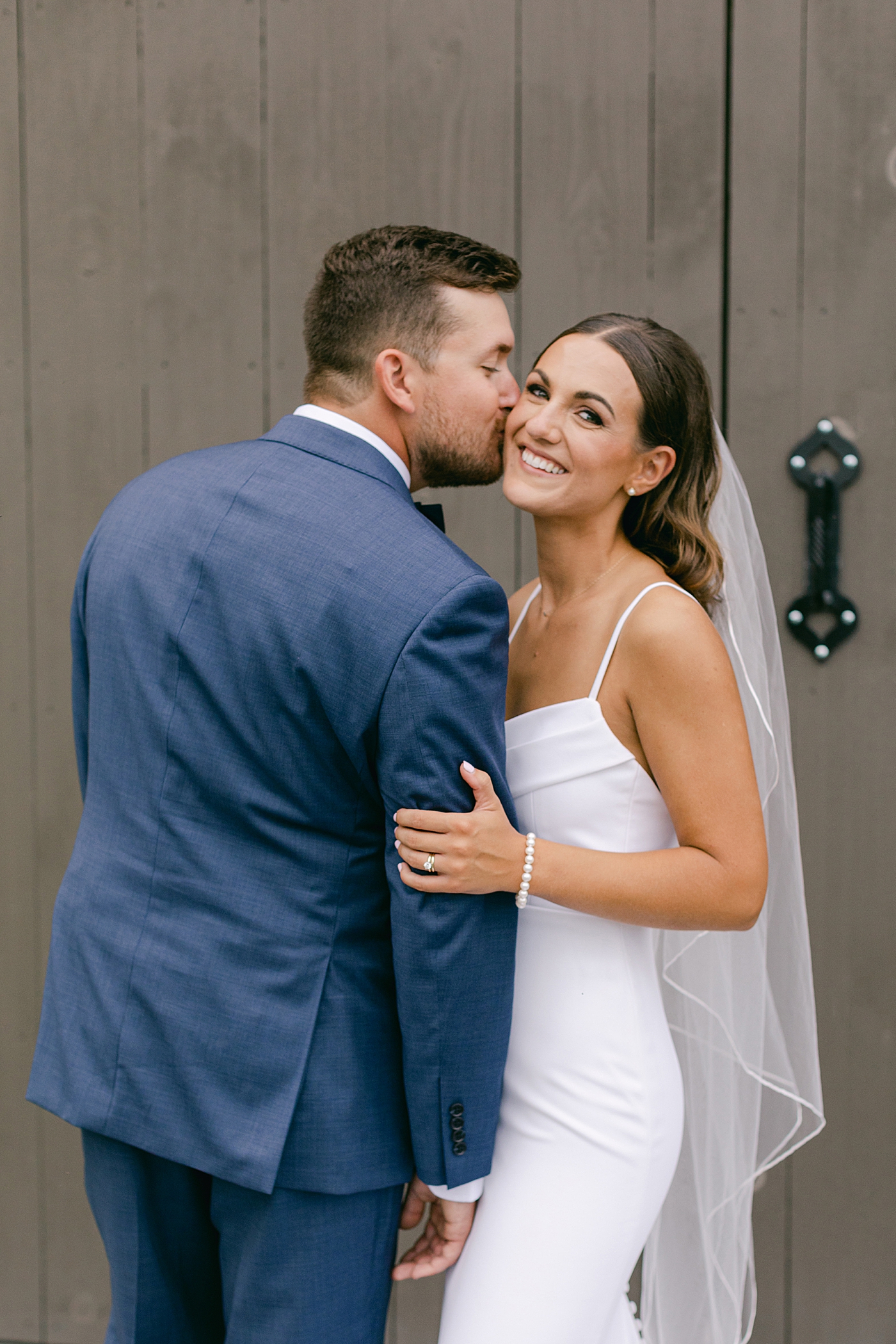 Groom kissing bride during couple portraits | Image by Hope Helmuth Photography