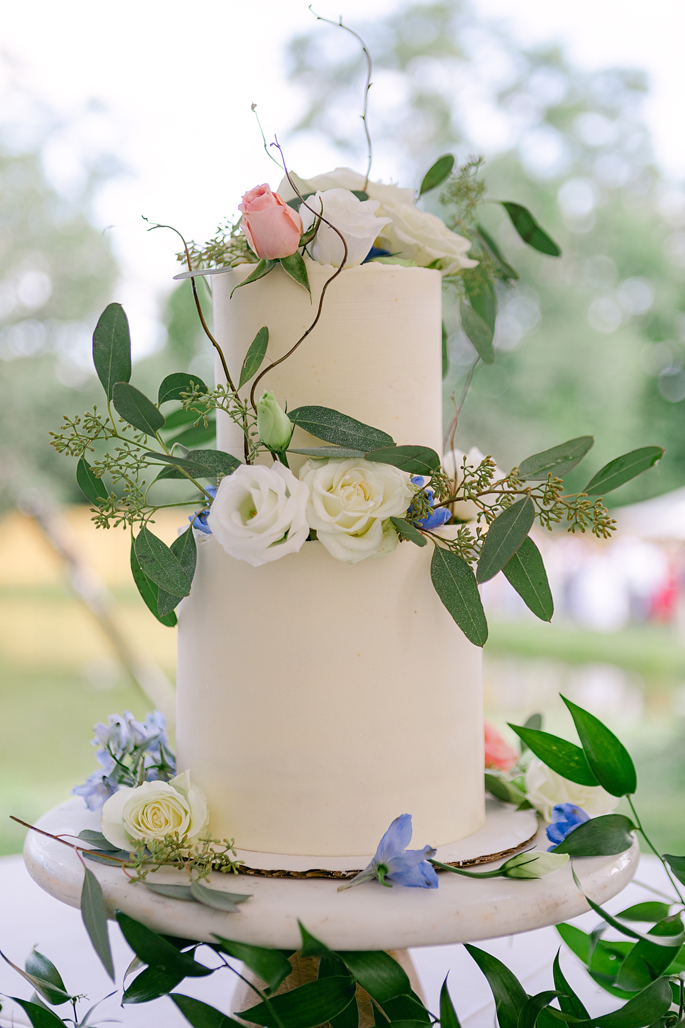 Wedding cake with flowers and greenery | Image by Hope Helmuth Photography