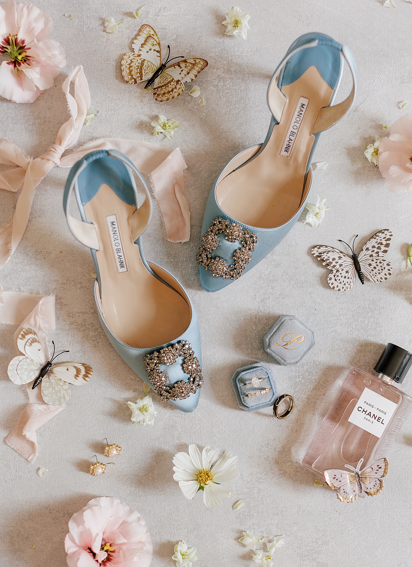 Light blue Manolo Blahnik heels styled with flowers and butterflies | Image by Hope Helmuth Photography