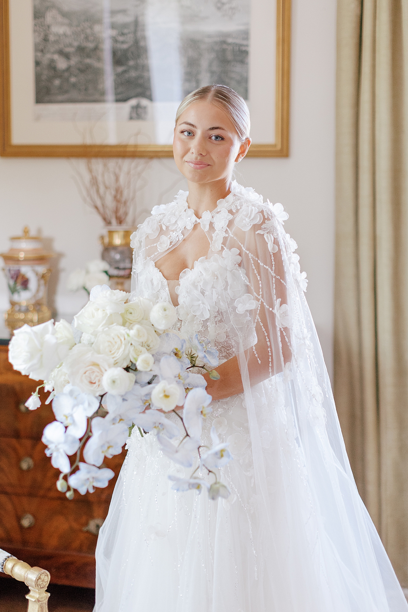 Bride with bouquet and cape smiling | Image by Hope Helmuth Photography