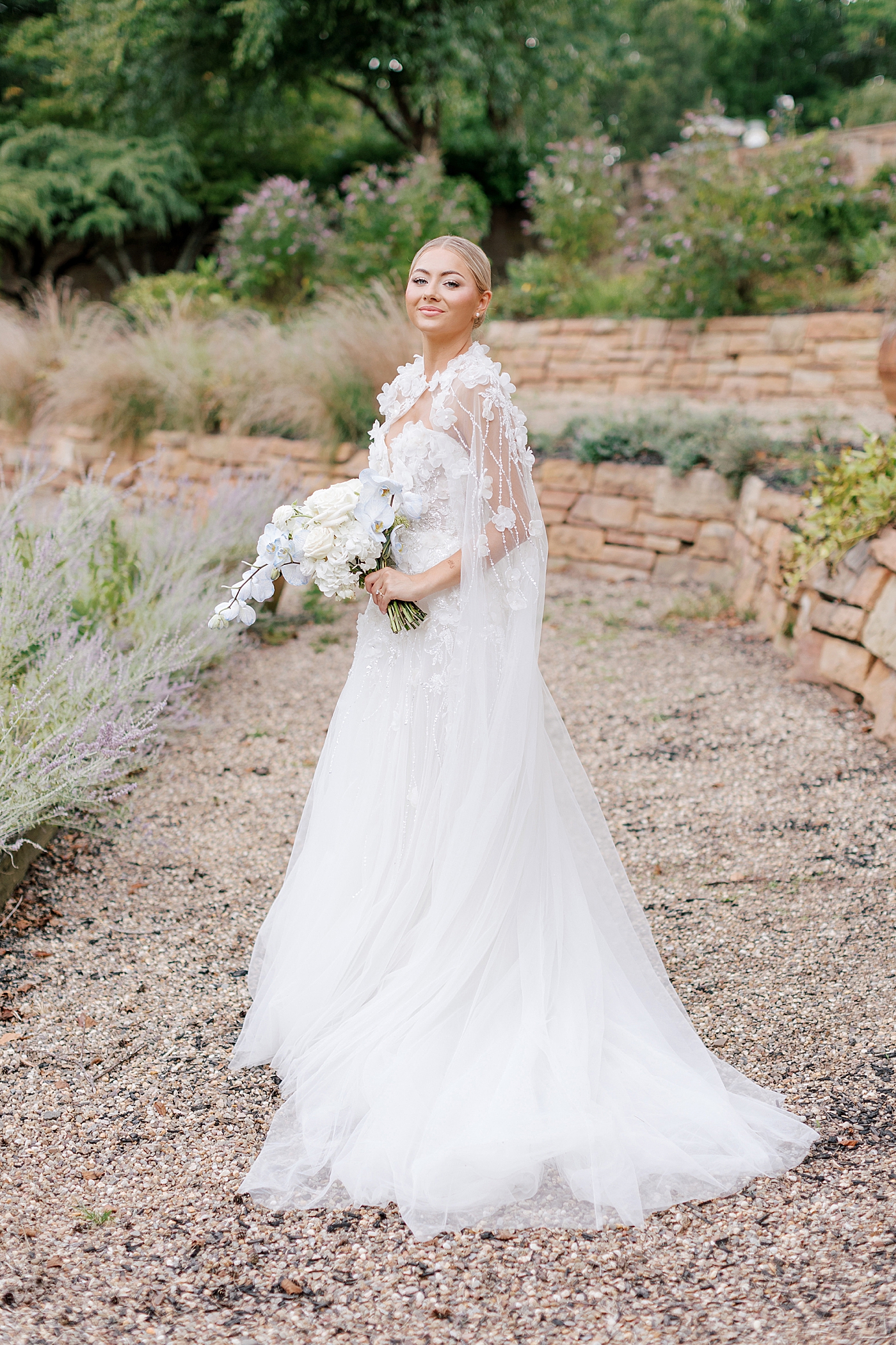 Bride with bouquet in a garden with lavender | Image by Hope Helmuth Photography