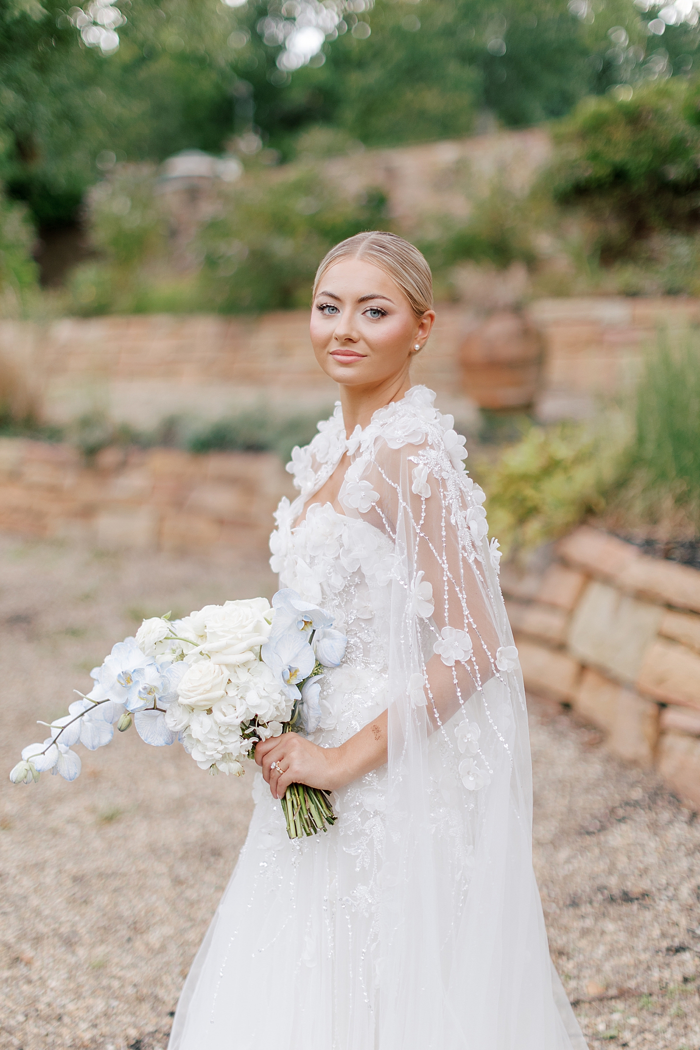 Bride with bouquet looking over her shoulder | Image by Hope Helmuth Photography