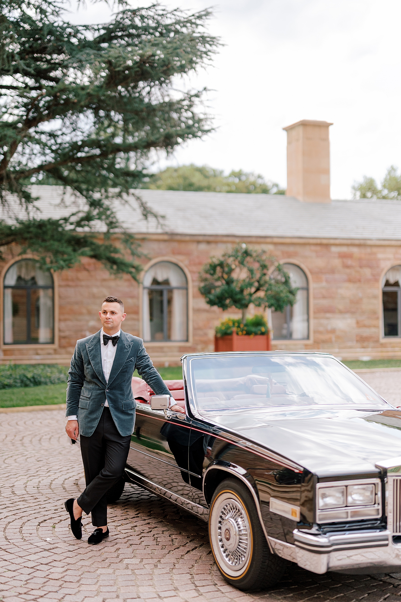 Groom in velvet blue tux by a vintage car | Image by Hope Helmuth Photography