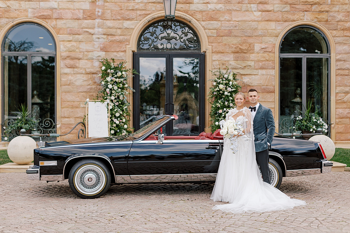 Bride and groom near vintage black car | Image by Hope Helmuth Photography
