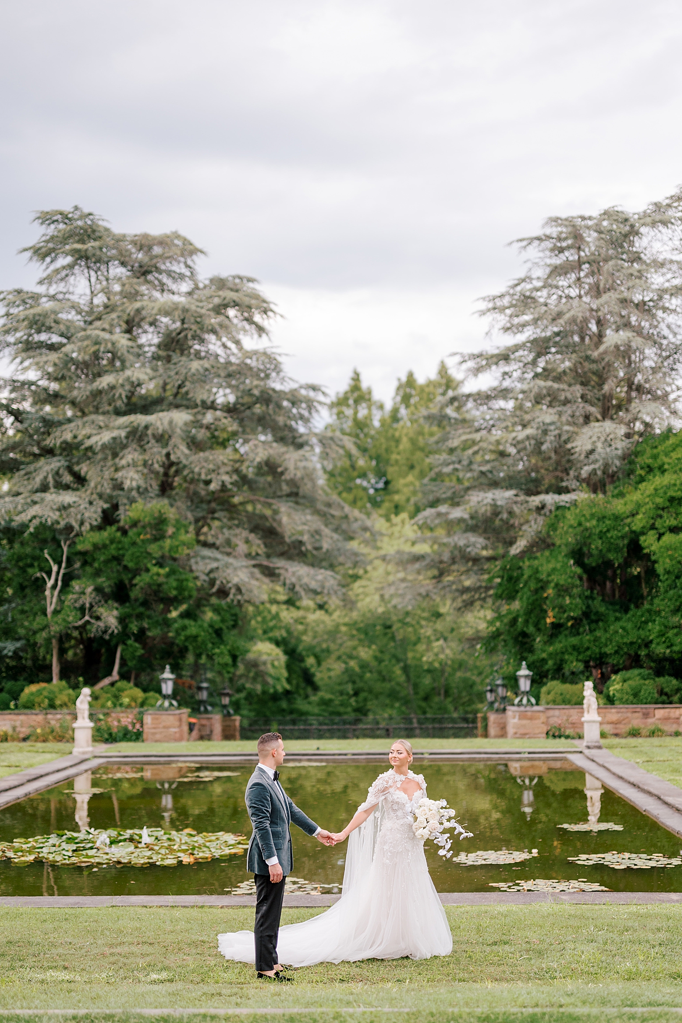 Bride and groom walking near a pond | Image by Hope Helmuth Photography