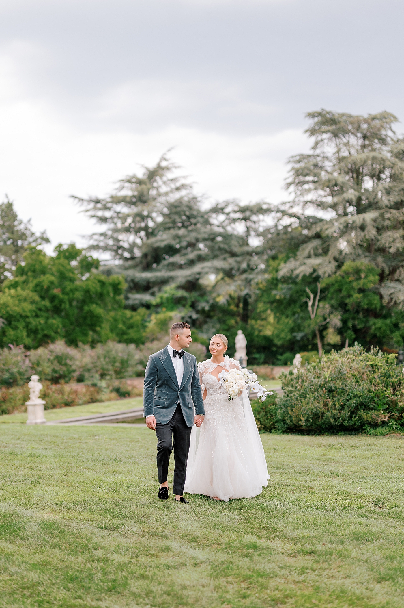 Bride and groom walking through a garden | Image by Hope Helmuth Photography