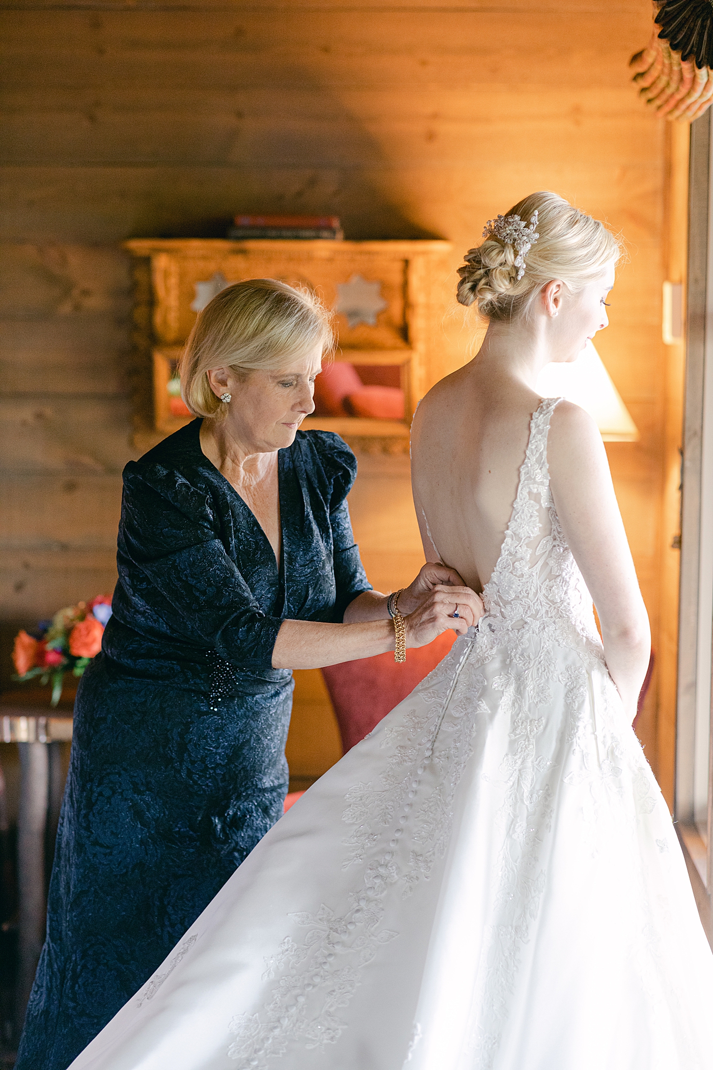 Bride being helped into her dress | Image by Hope Helmuth Photography