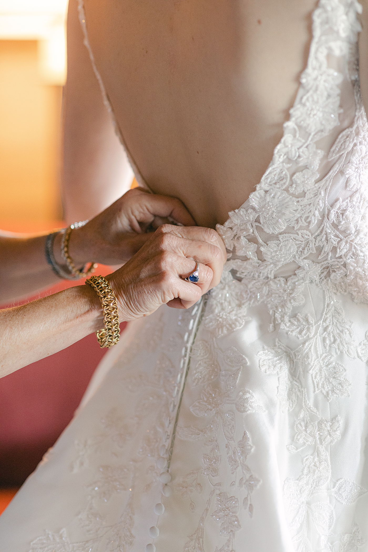 Detail of mother of bride zipping her dress | Image by Hope Helmuth Photography
