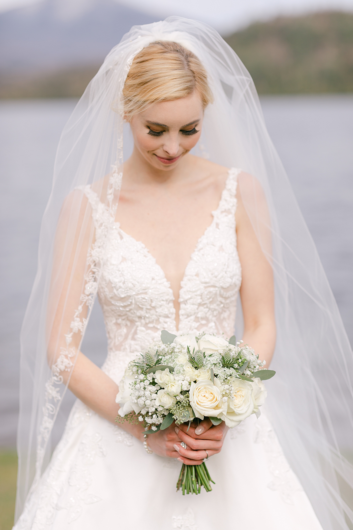 Bride wearing a veil holding a bouquet | Image by Hope Helmuth Photography
