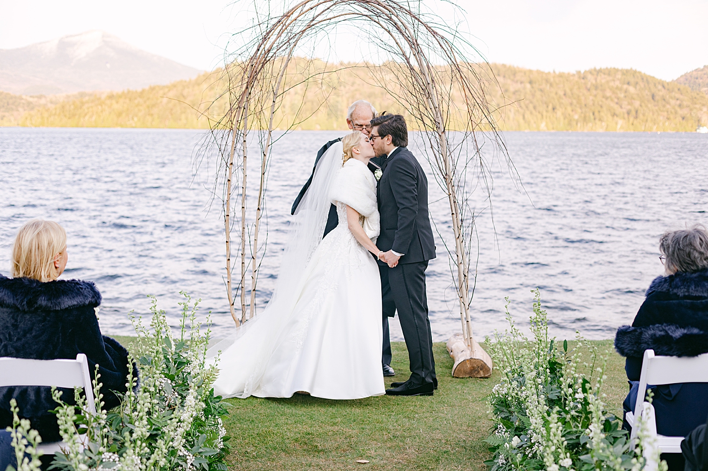 Bride and groom first kiss during Lake Placid Lodge Wedding | Image by Hope Helmuth Photography
