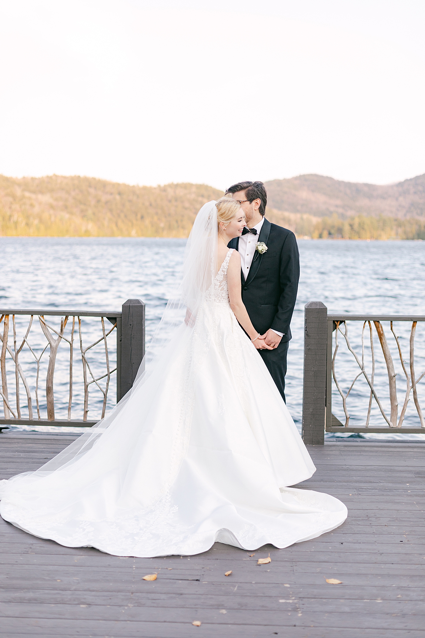 Bride and groom embracing on a dock | Image by Hope Helmuth Photography