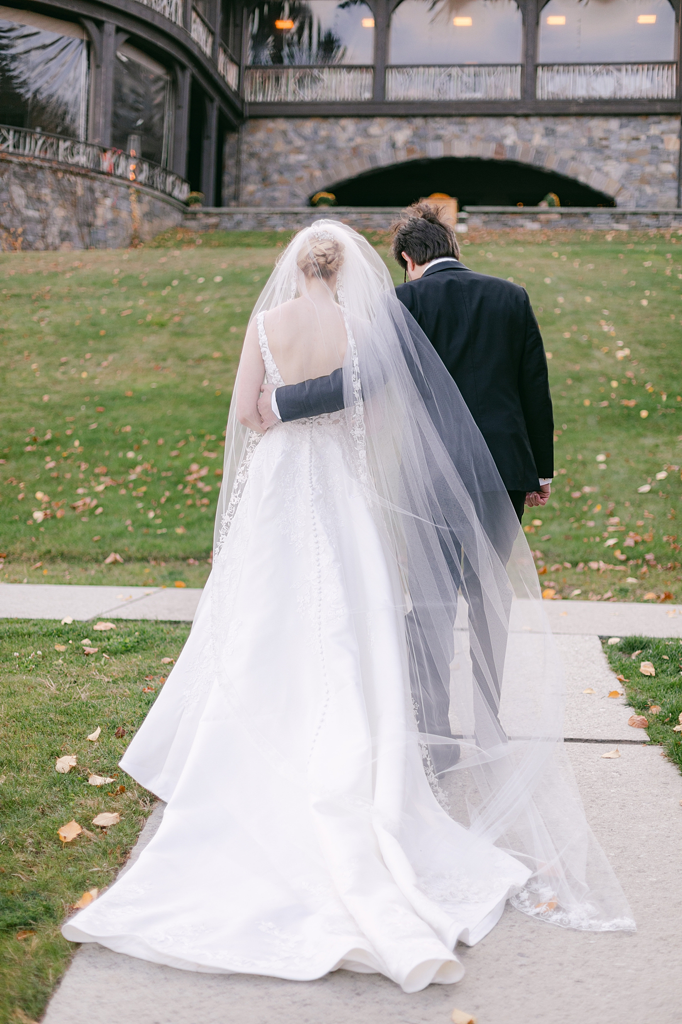 Bride and groom walking to their reception during Lake Placid Lodge Wedding | Image by Hope Helmuth Photography