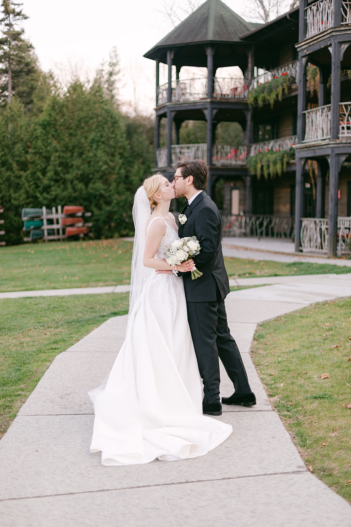 Bride and groom kissing near lodge | Image by Hope Helmuth Photography