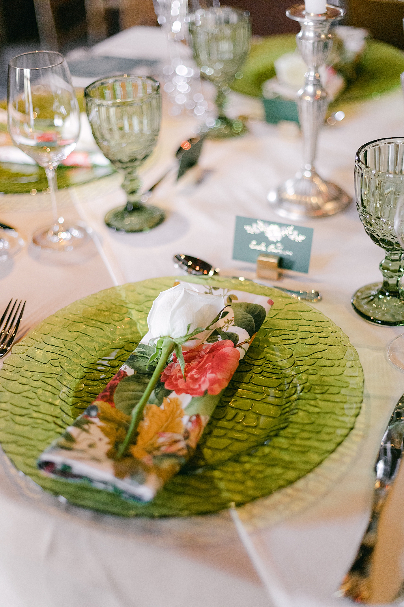 Detail of place setting with green plate and floral napkin | Image by Hope Helmuth Photography