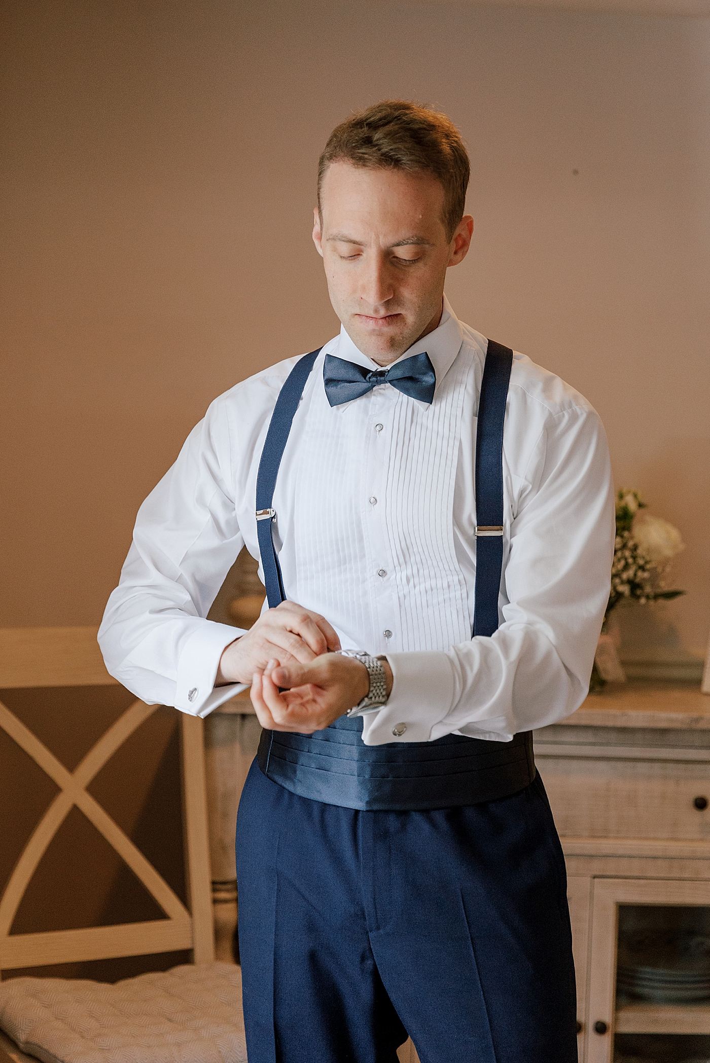 Groom adjusting his cufflinks during River House Odette's Wedding | Image by Hope Helmuth Photography