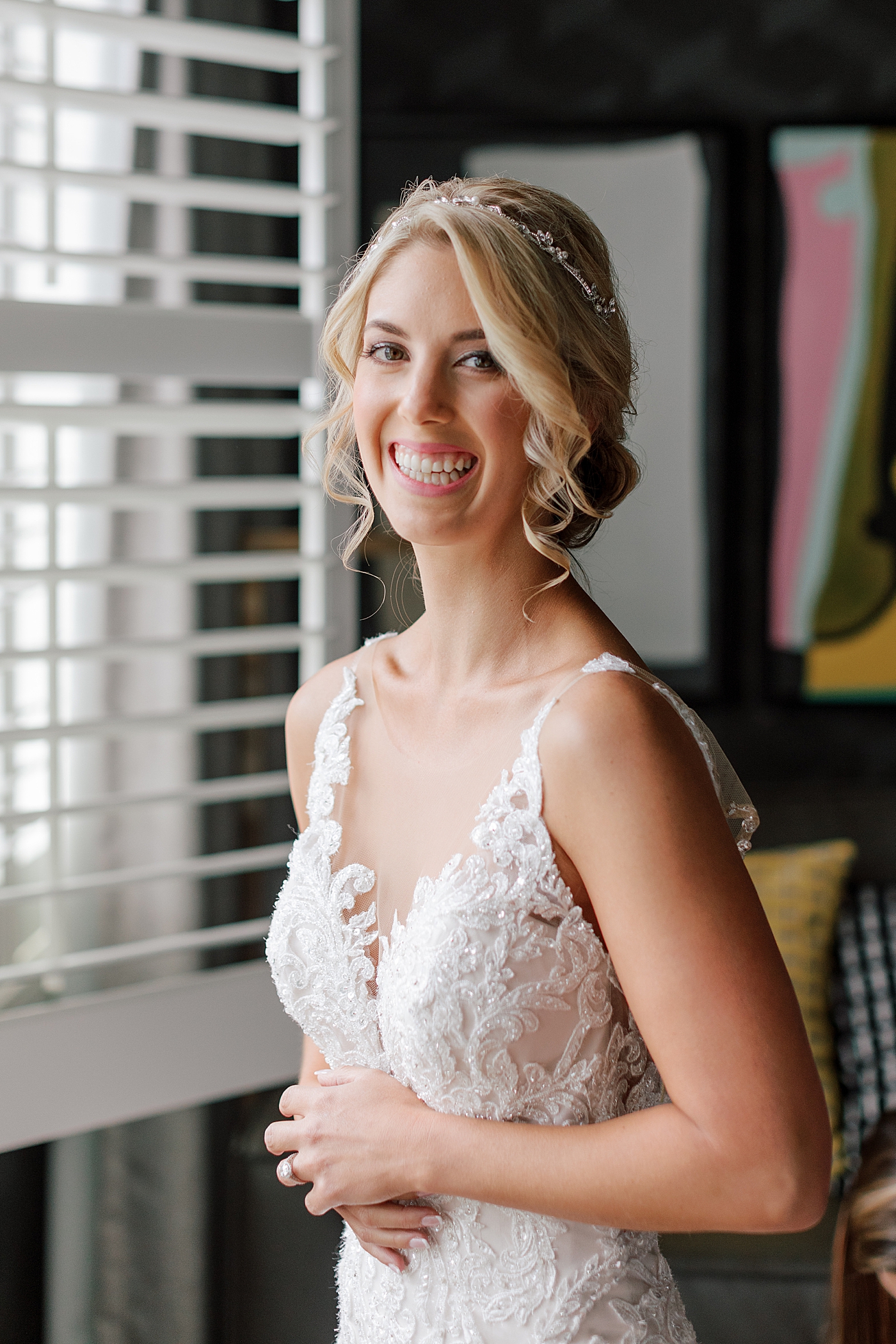 Bride smiling near a window during River House Odette's Wedding | Image by Hope Helmuth Photography