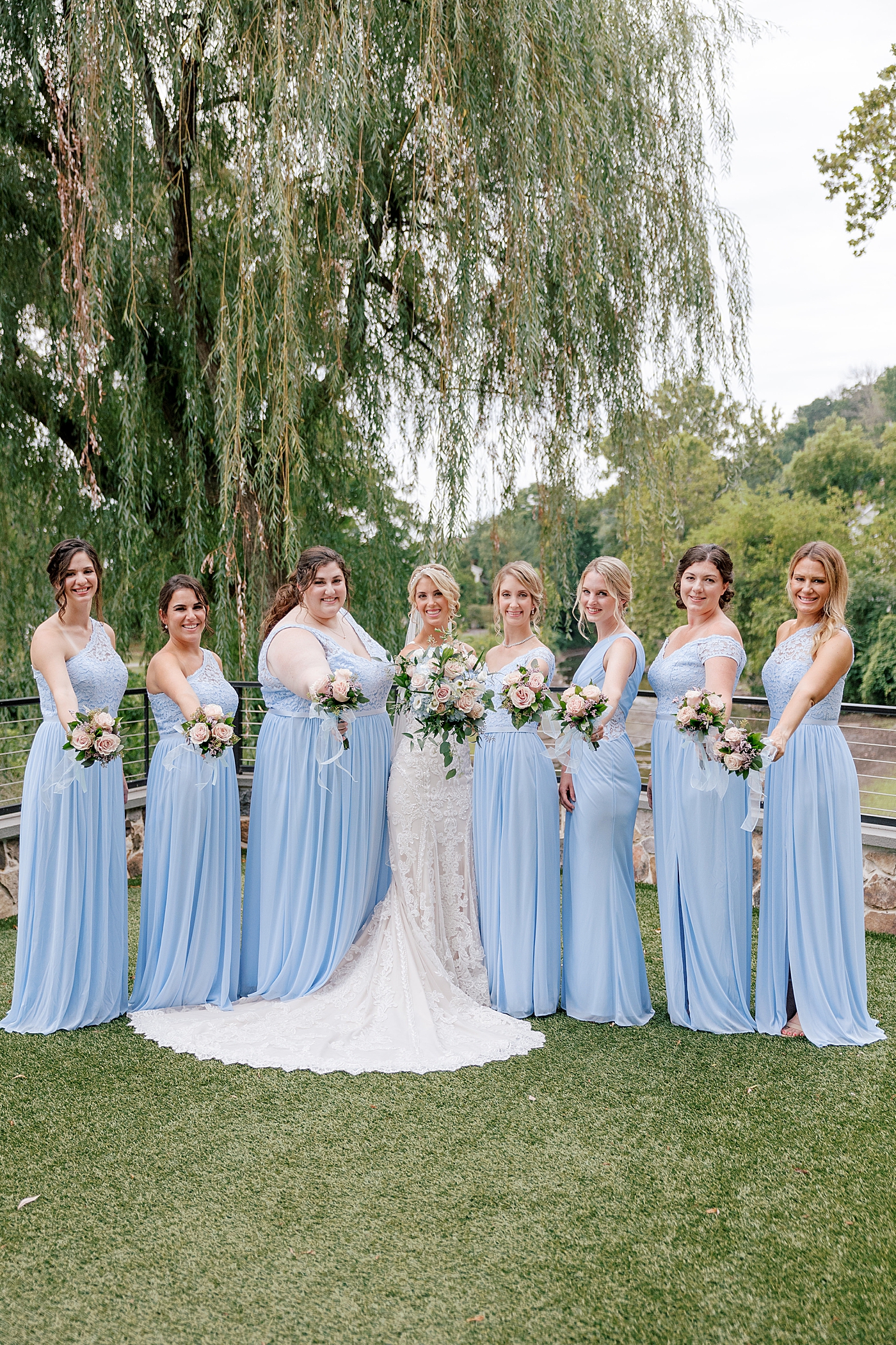 Bride with her bridesmaids holding their flowers during River House Odette's Wedding | Image by Hope Helmuth Photography