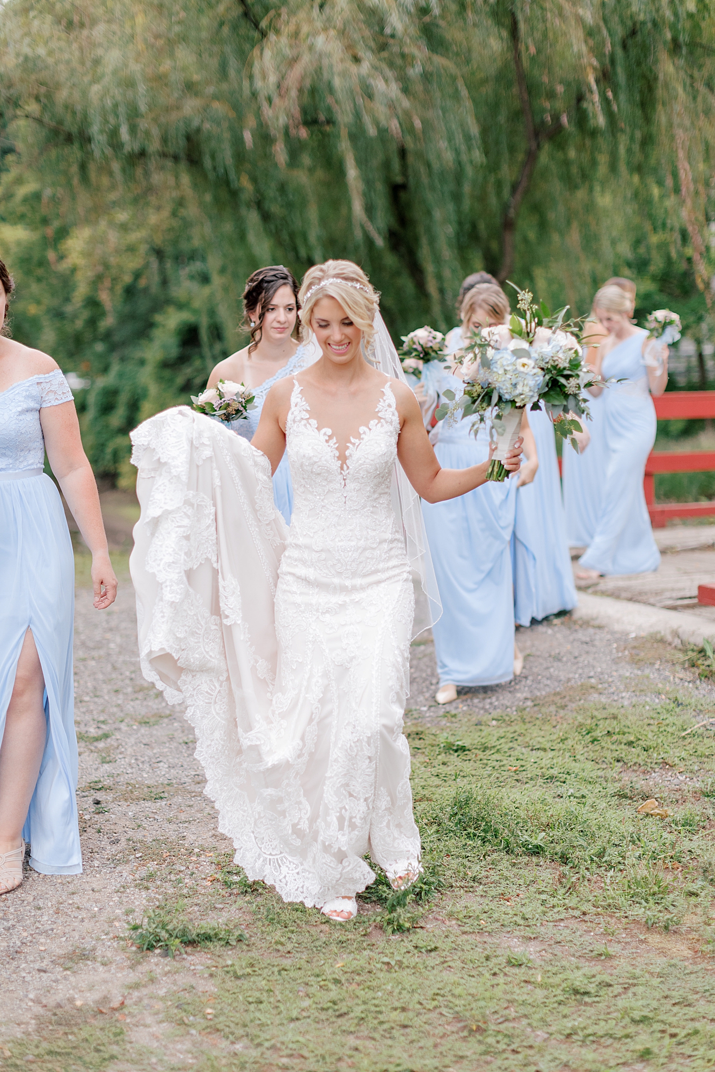 Bride and bridesmaids walking over a bridge | Image by Hope Helmuth Photography