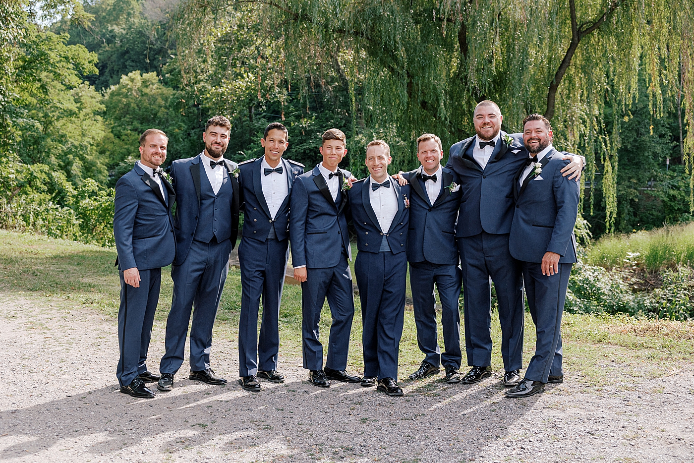 Groomsmen with their arms all around each other | Image by Hope Helmuth Photography