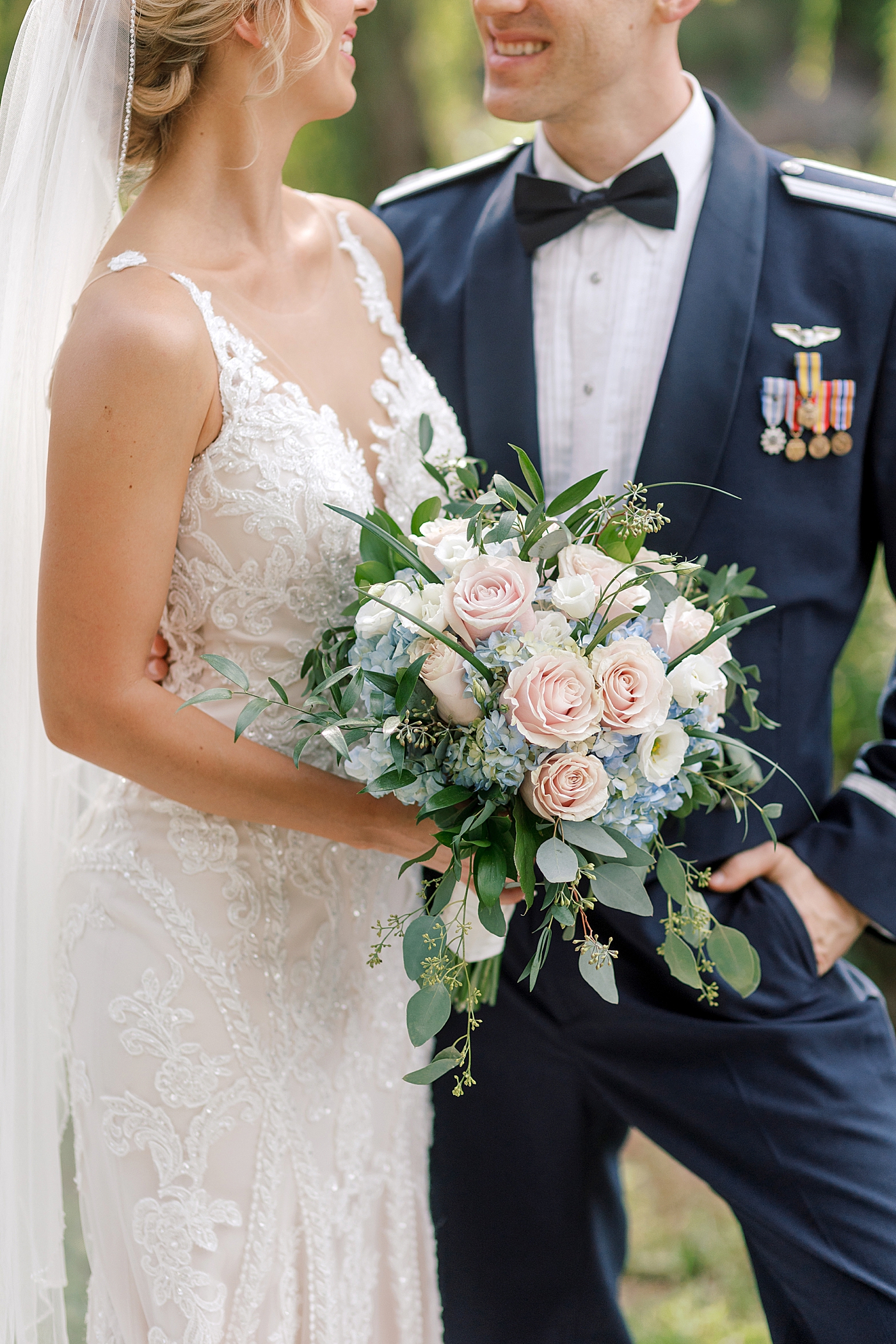 Detail of bride and groom holding a bouquet | Image by Hope Helmuth Photography