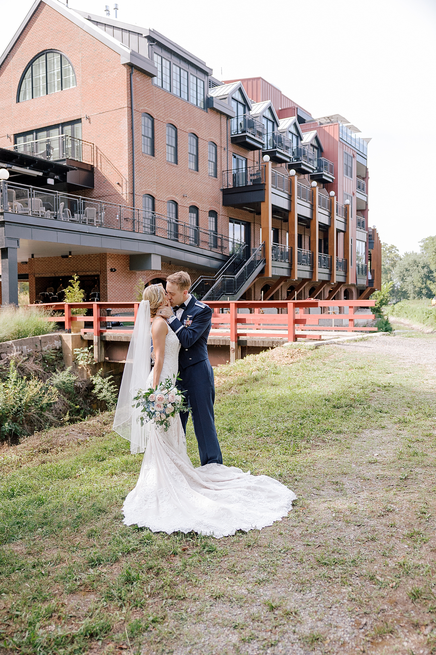 Bride and groom kiss in front of wedding venue | Image by Hope Helmuth Photography