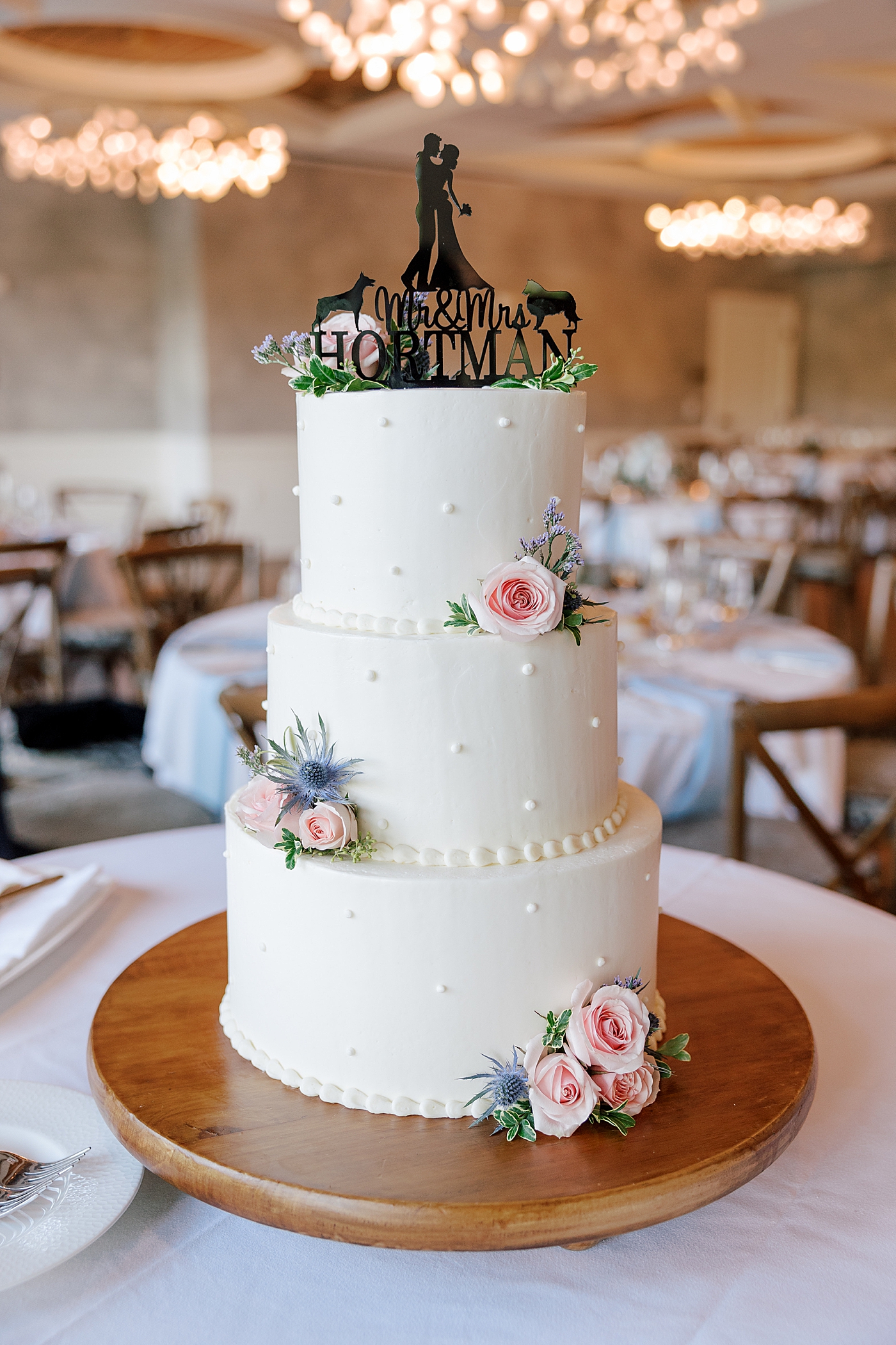 Wedding cake with polka dots and black cake topper | Image by Hope Helmuth Photography