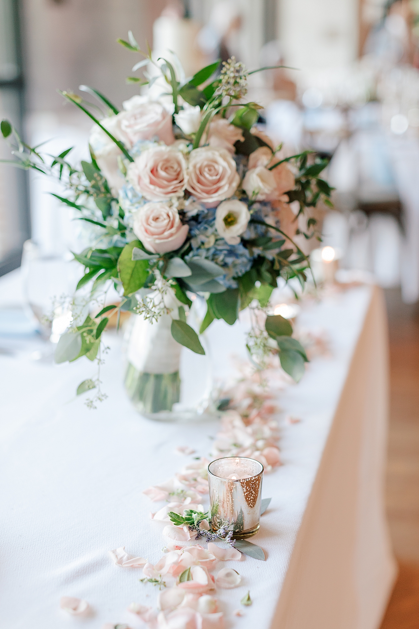 Wedding reception table with flowers and candles during River House Odette's Wedding | Image by Hope Helmuth Photography