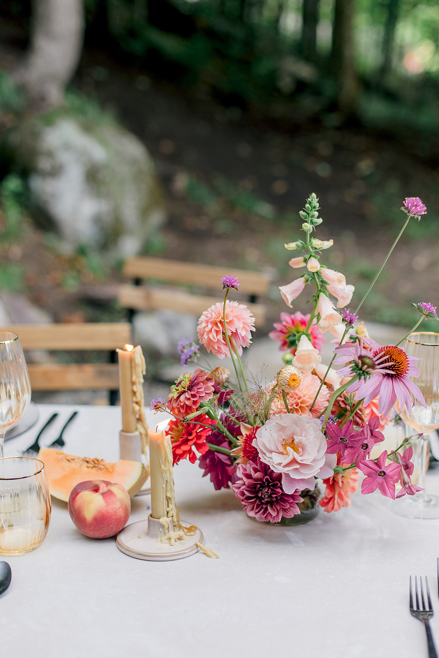 Bright colored flowers with tapered candles and fruit during Adirondack Mountain Elopement Weekend | Image by Hope Helmuth Photography