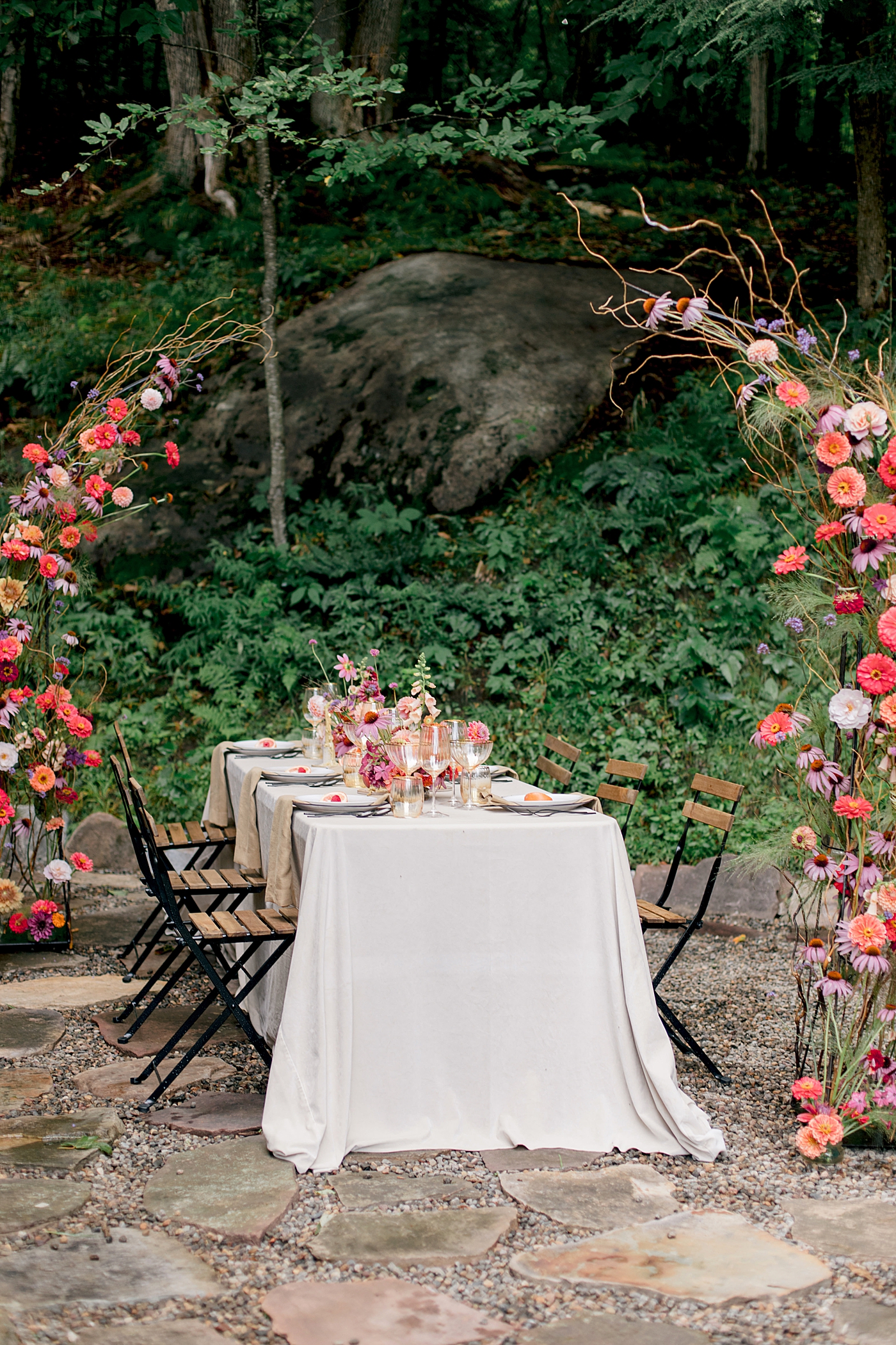 Reception table with colorful flower arbor during Adirondack Mountain Elopement Weekend | Image by Hope Helmuth Photography