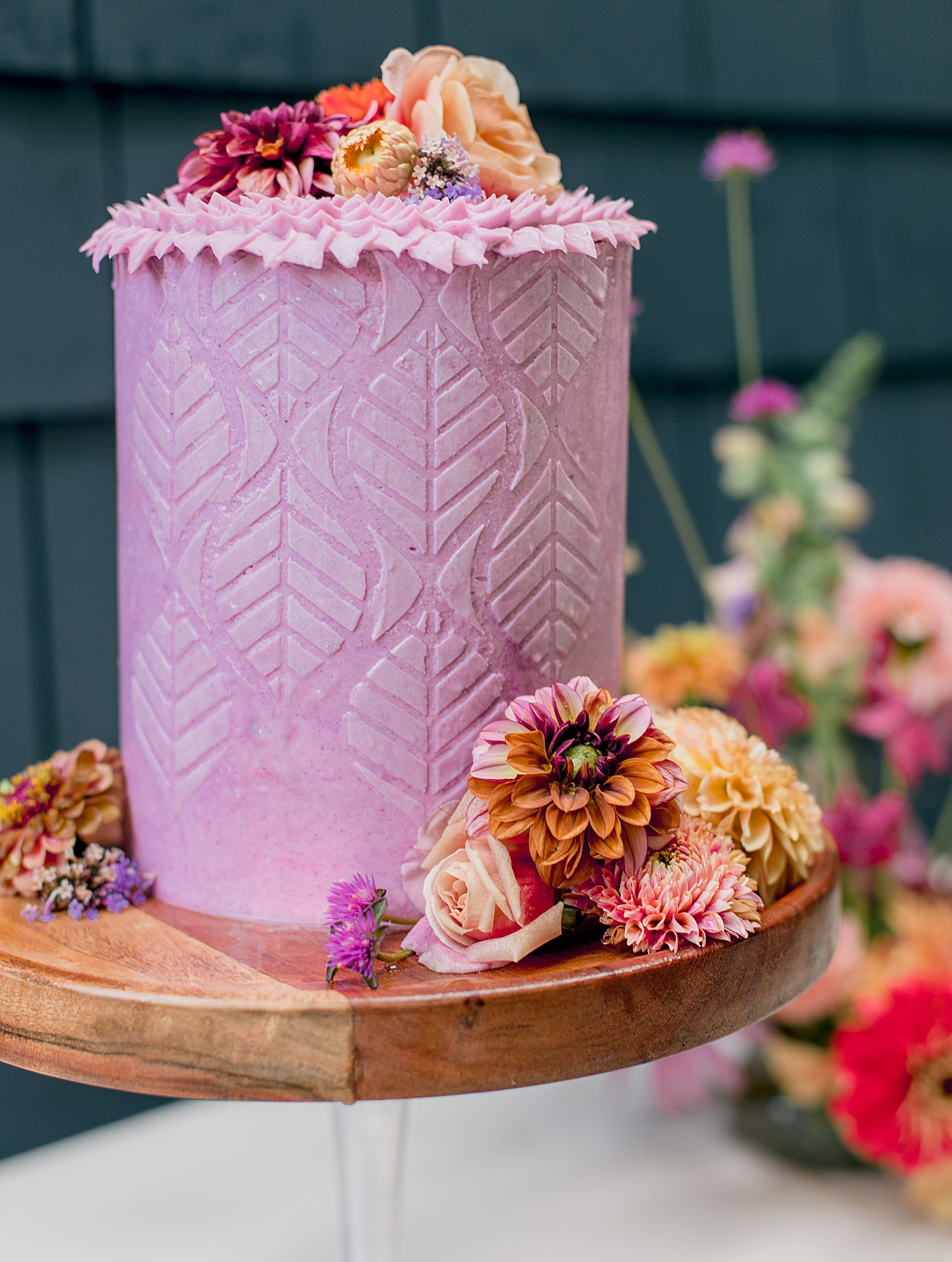 Purple wedding cake with stencil details decorated by colorful flowers | Image by Hope Helmuth Photography