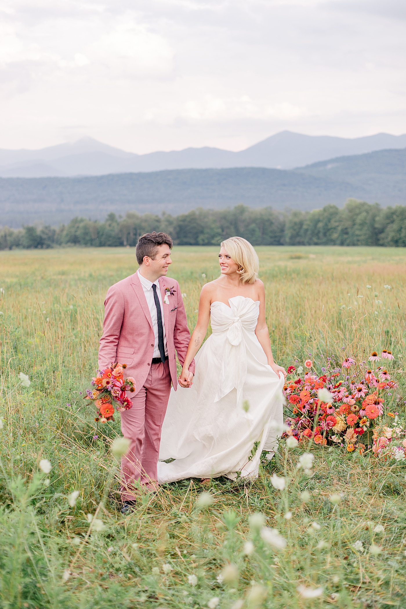 Couple in bright colors walking in a field | Image by Hope Helmuth Photography