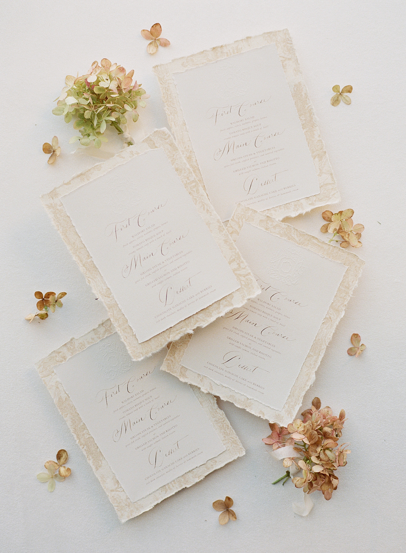 Overhead flat lay of a wedding invitation on scalloped, paper with handwritten calligraphy | Image by Hope Helmuth Photography