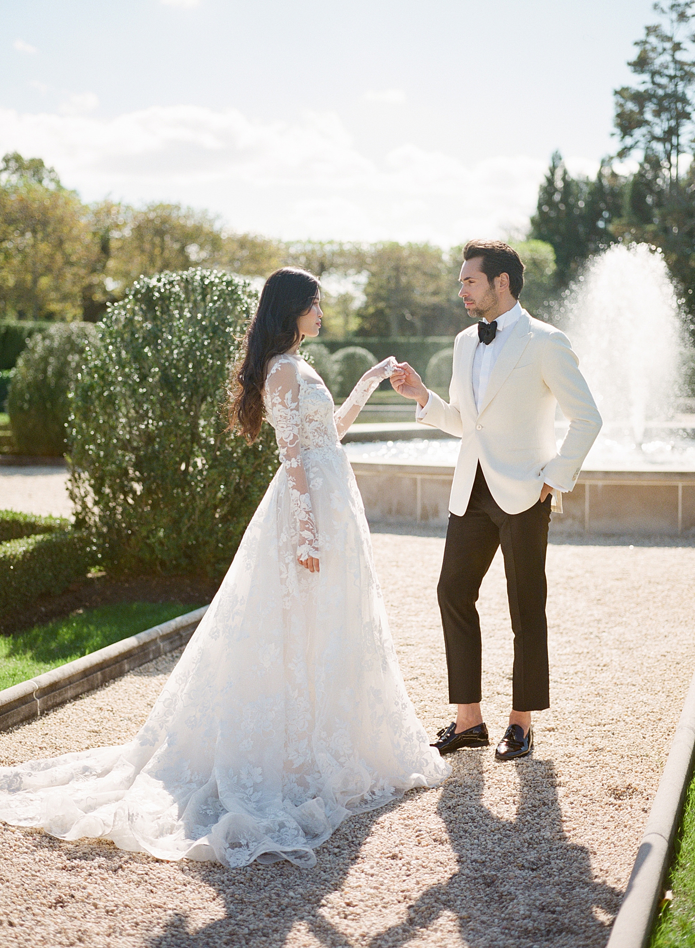 Image of a bride and groom dancing in a European garden with a fountain during Oheka castle wedding | Image by Hope Helmuth Photography
