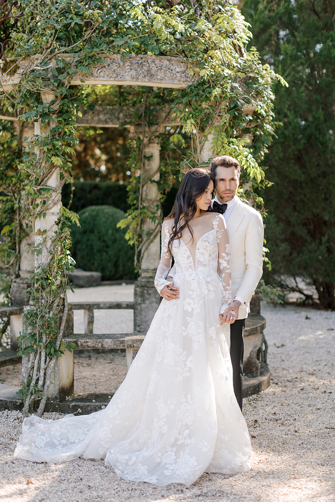 Image of a bride and groom standing together in a European garden during Oheka castle wedding | Image by Hope Helmuth Photography