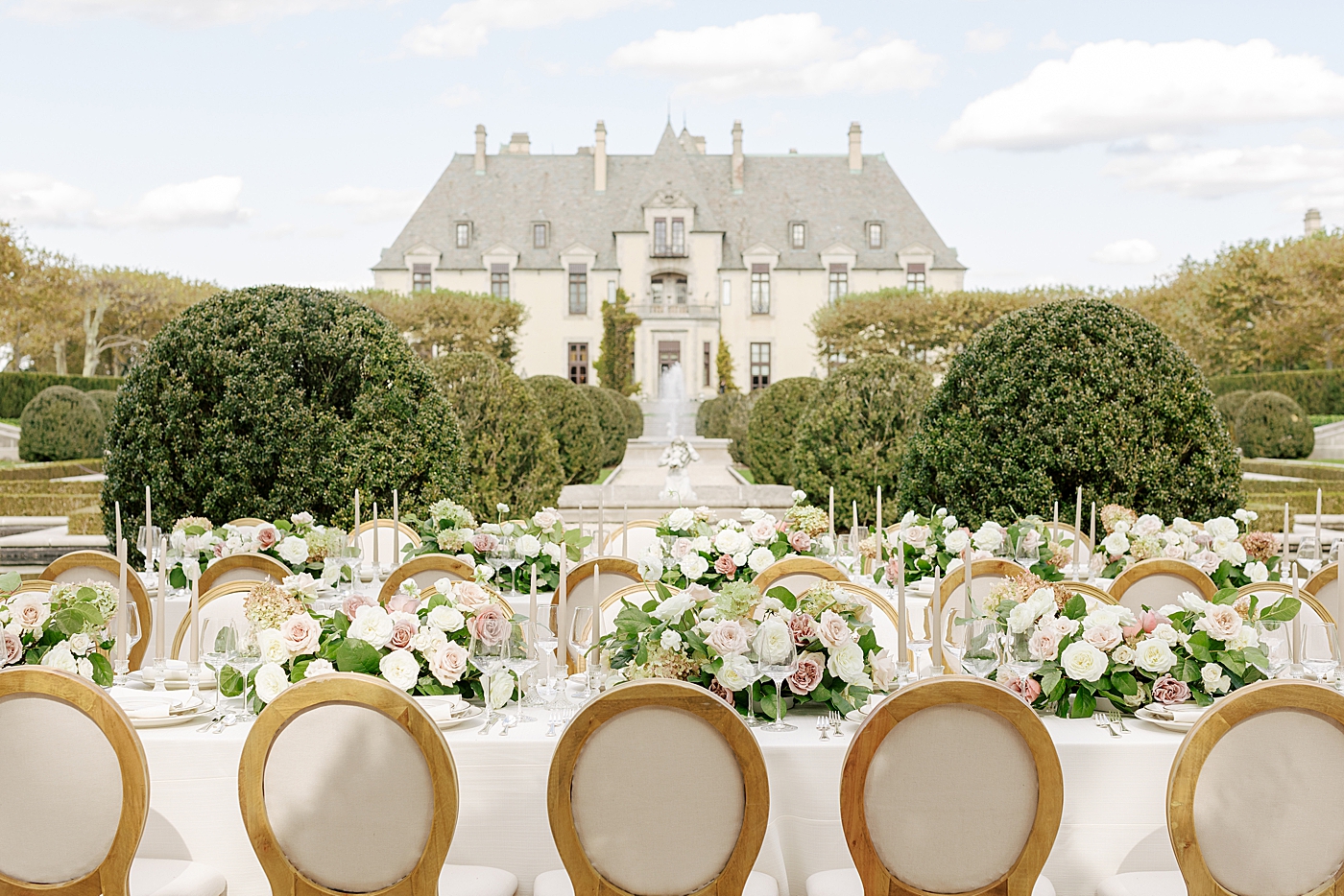 Details of a table setting with white flowers and white table cloths in a European garden during Oheka castle wedding | Image by Hope Helmuth Photography