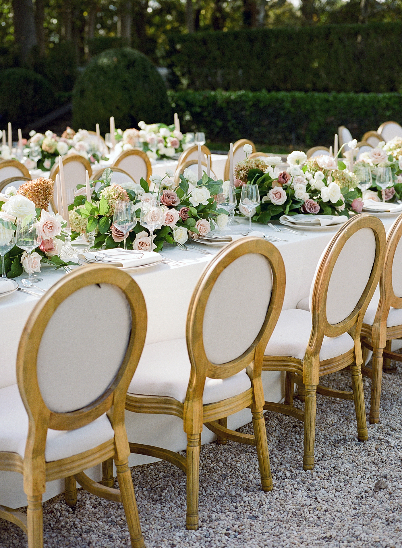 Details of a table setting with white flowers and white table cloths in a European garden during Oheka castle wedding | Image by Hope Helmuth Photography