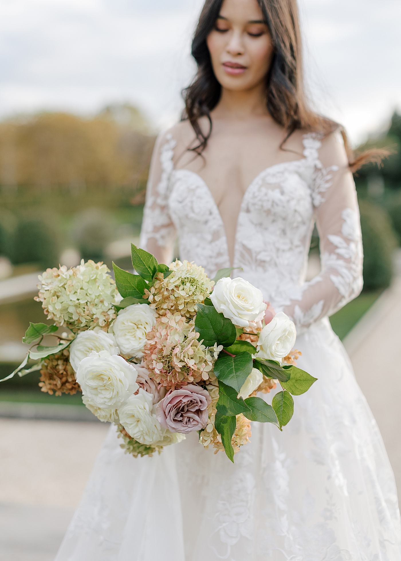 Bride posing with flowers during Oheka castle wedding | Image by Hope Helmuth Photography
