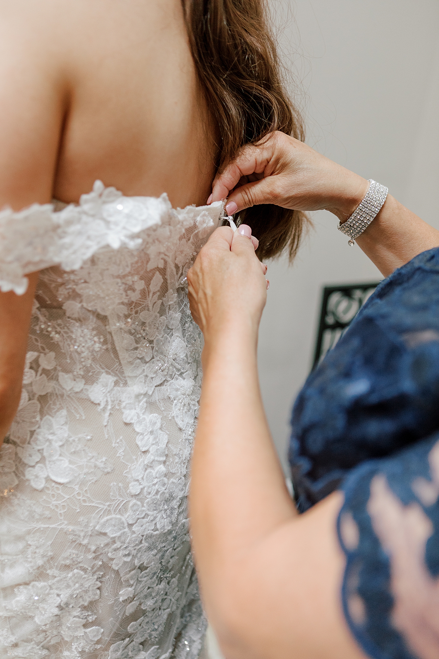 Detail of bride being zipped into her gown | Image by Hope Helmuth Photography 