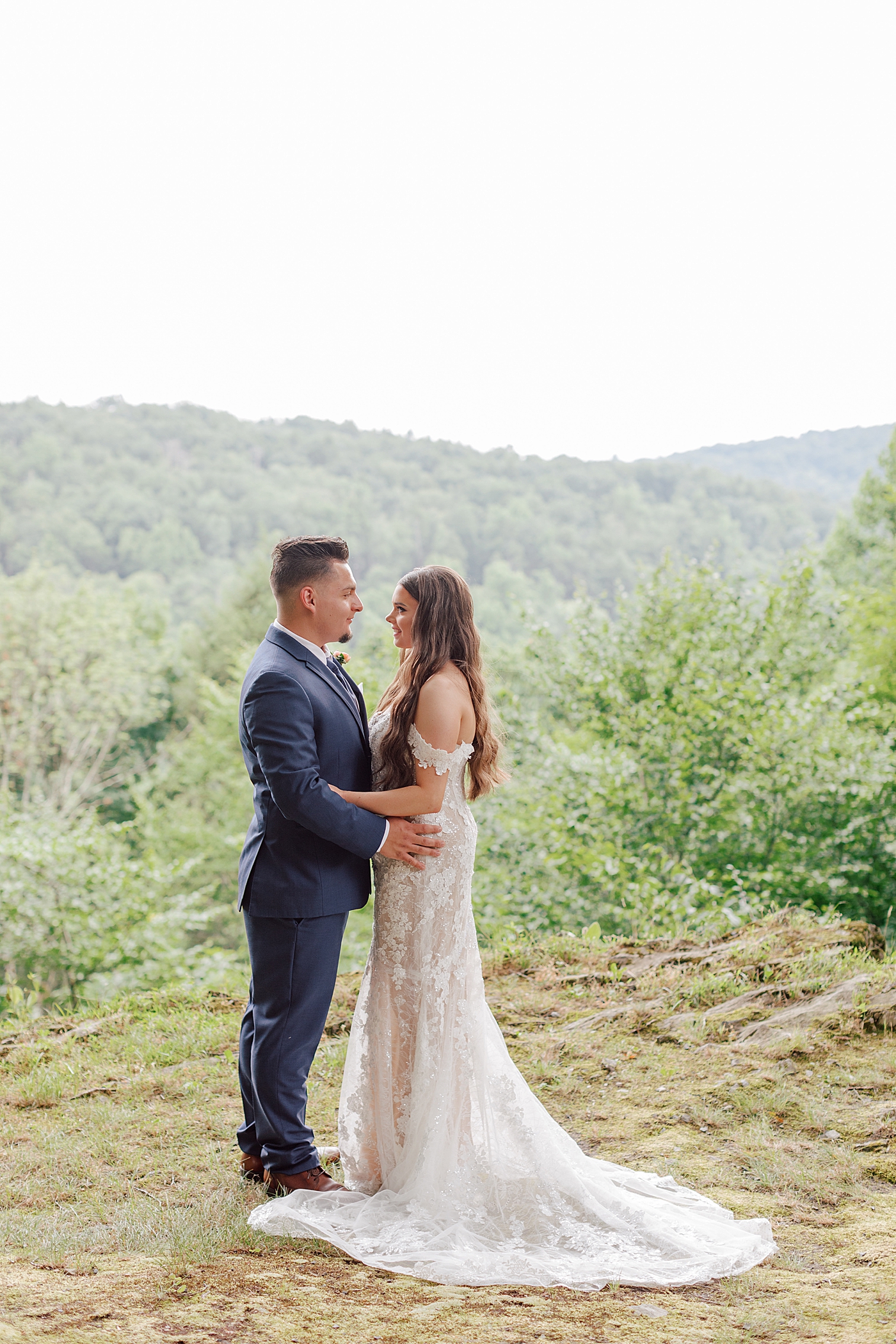 Bride and groom embracing with mountains in the background | Image by Hope Helmuth Photography 
